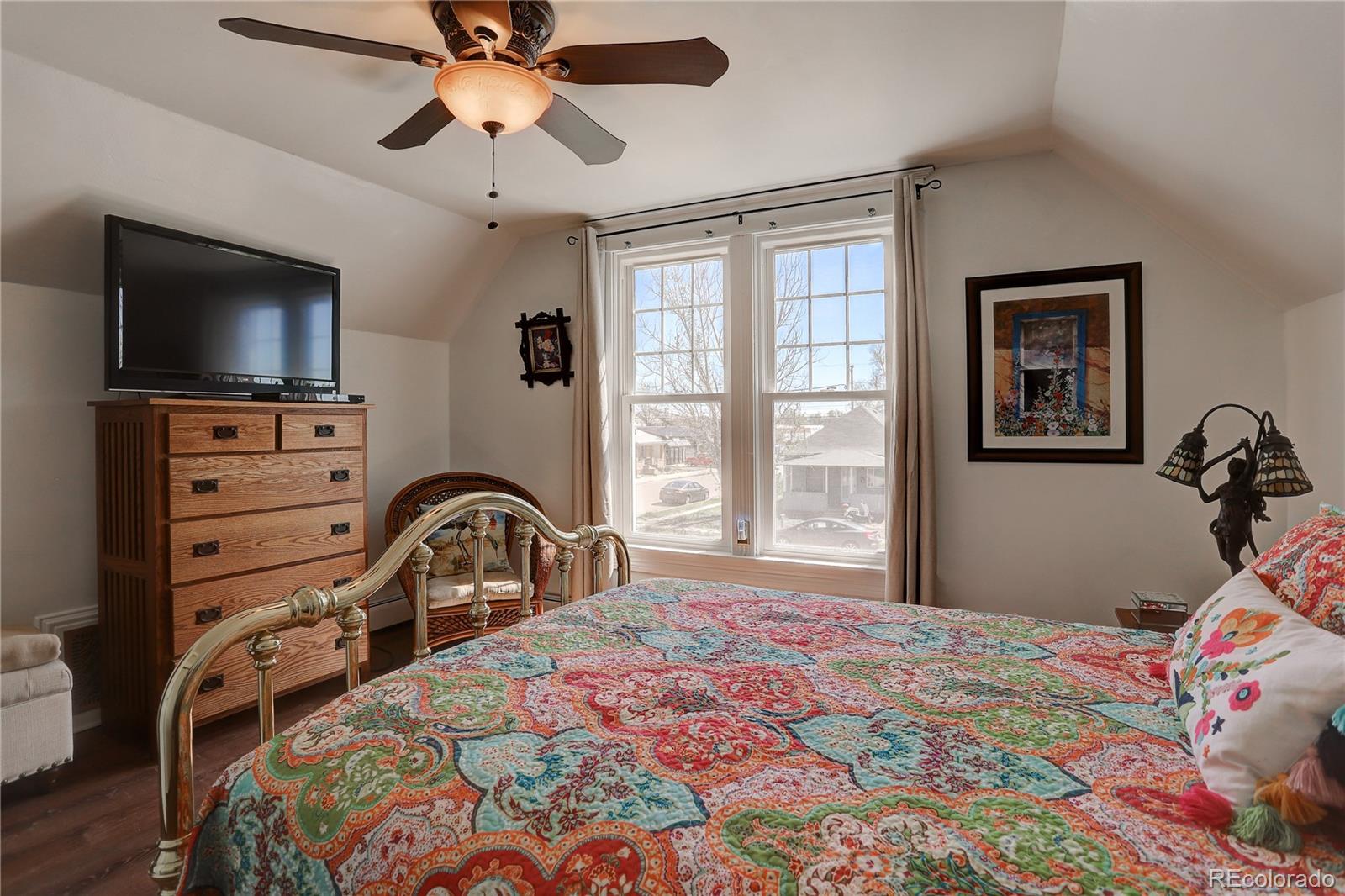 153 Park Avenue Fort Lupton, CO 80621 - Photo 23 of 35 a bedroom with a bed and a flat tv screen on dresser