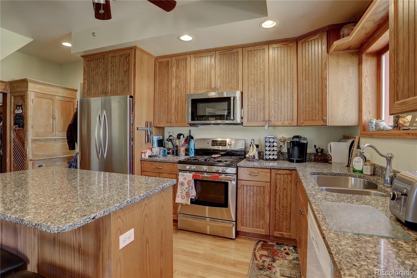 153 Park Avenue Fort Lupton, CO 80621 - Photo 6 of 35 a kitchen with stainless steel appliances granite countertop a stove top oven a sink and dishwasher