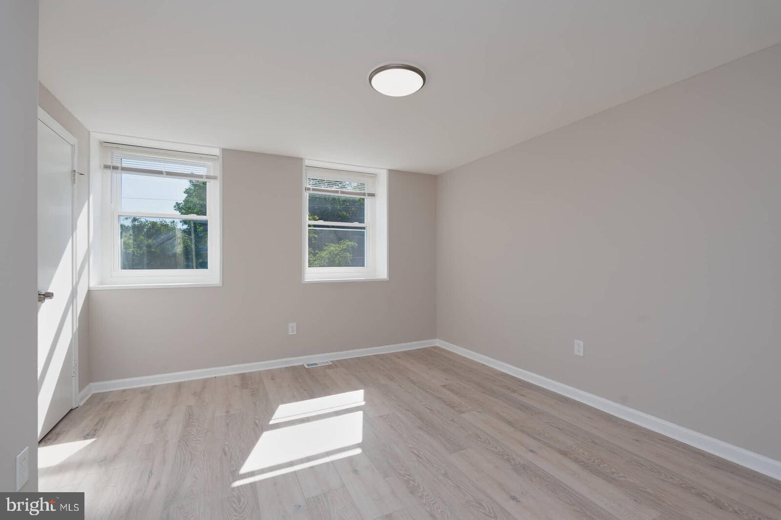 1842 Dutch Village Drive, Unit R264 Landover, MD 20785 - Photo 18 of 26 an empty room with wooden floor and windows