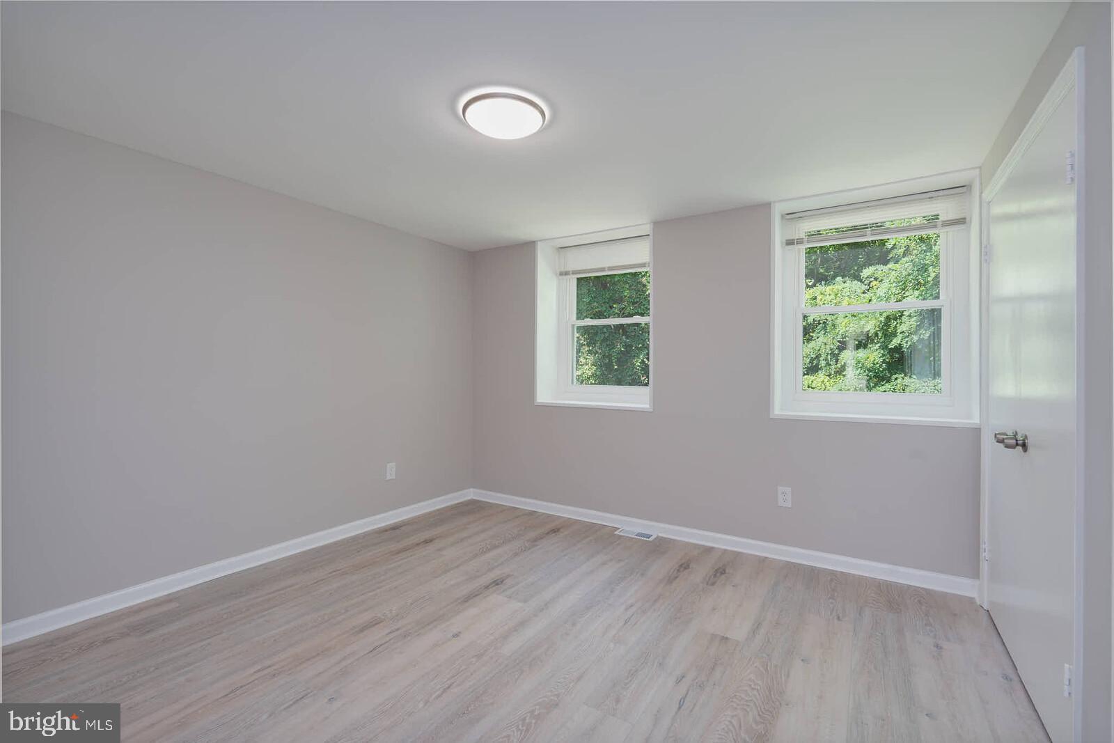 1842 Dutch Village Drive, Unit R264 Landover, MD 20785 - Photo 21 of 26 an empty room with wooden floor and windows
