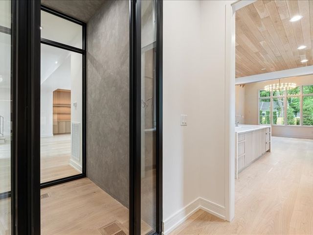 a living room with a large window and chandelier