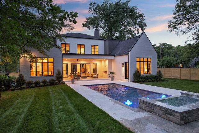 a view of a house with a big yard and sitting area