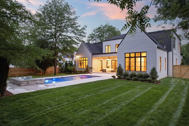 a view of a swimming pool with a big yard and large trees