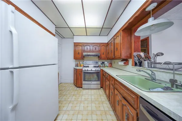 a kitchen with stainless steel appliances granite countertop a refrigerator a sink and a stove