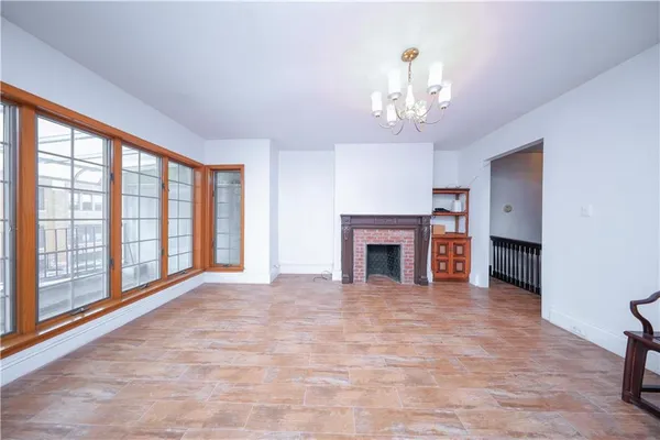 a view of an empty room with a fireplace and a window