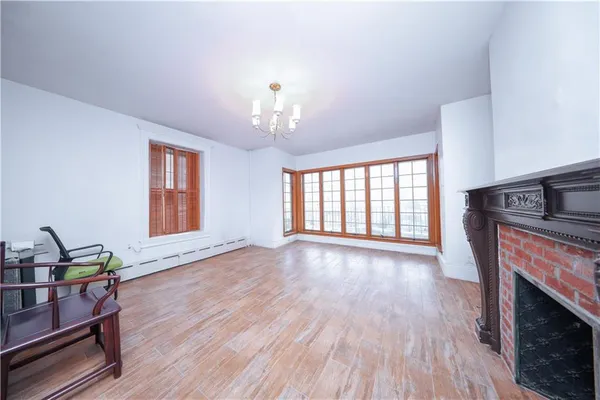 a view of a livingroom with furniture a fireplace and wooden floor