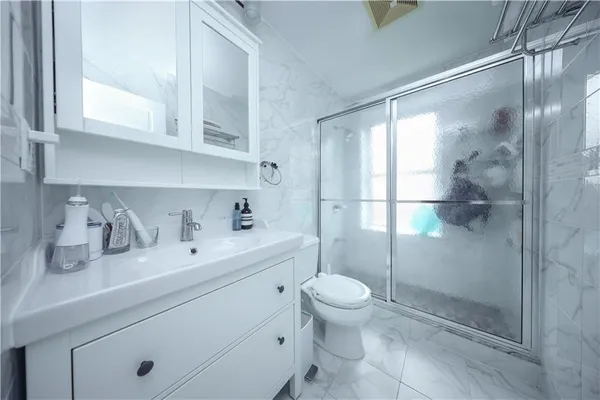 a bathroom with a sink a toilet and shower