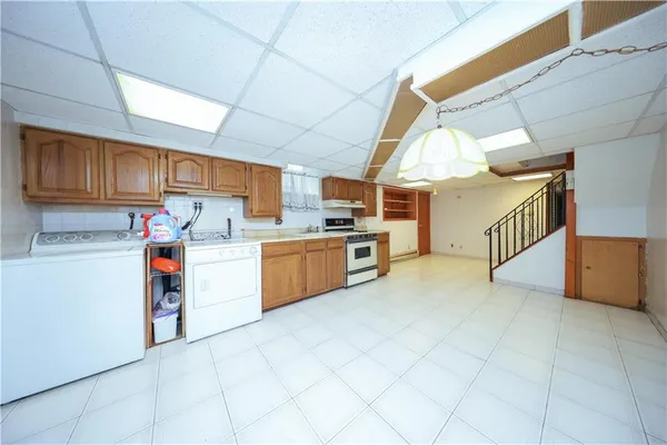 a open kitchen with cabinets and white appliances