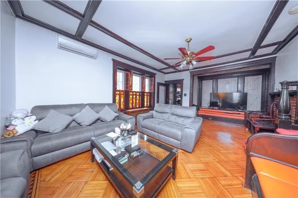 a living room with furniture a chandelier and a dining table with wooden floor
