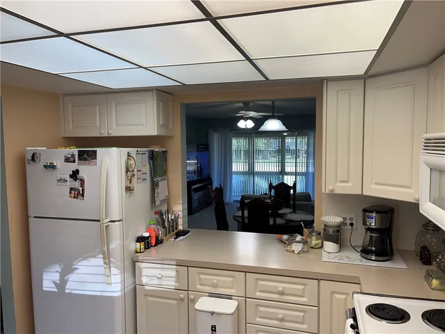 a kitchen with refrigerator and cabinets