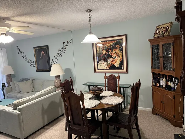 a dining room with furniture a chandelier and wooden floor