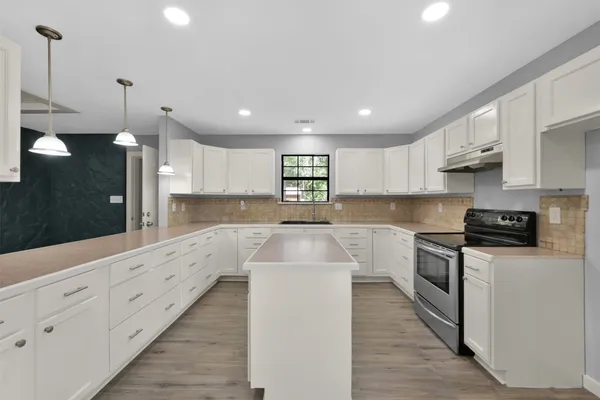 a view of empty room with wooden floor and white walls