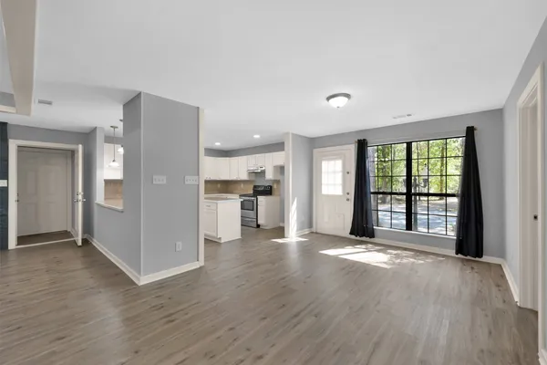 a large kitchen with stainless steel appliances kitchen island granite countertop a stove a sink a refrigerator and white cabinets