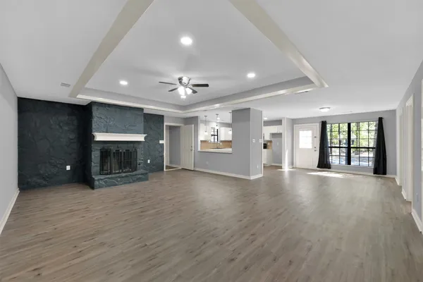 a view of a big room with wooden floor and a kitchen