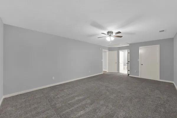 a view of an empty room with a chandelier fan