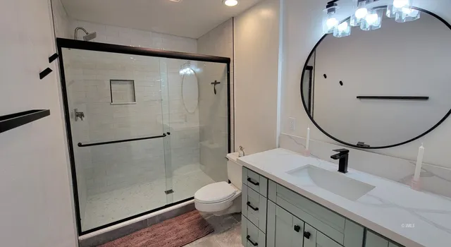 a bathroom with a sink a toilet and a mirror