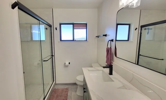 a bathroom with a sink a toilet and a mirror