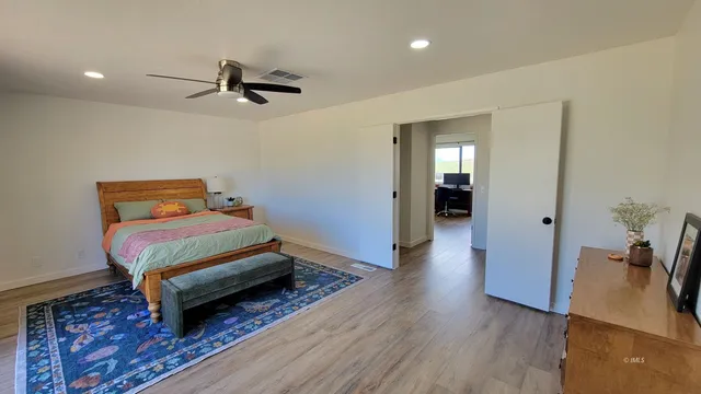 a bedroom with a bed and wooden floor