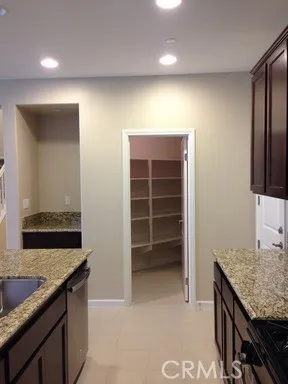 a kitchen with kitchen island granite countertop a sink stove and refrigerator