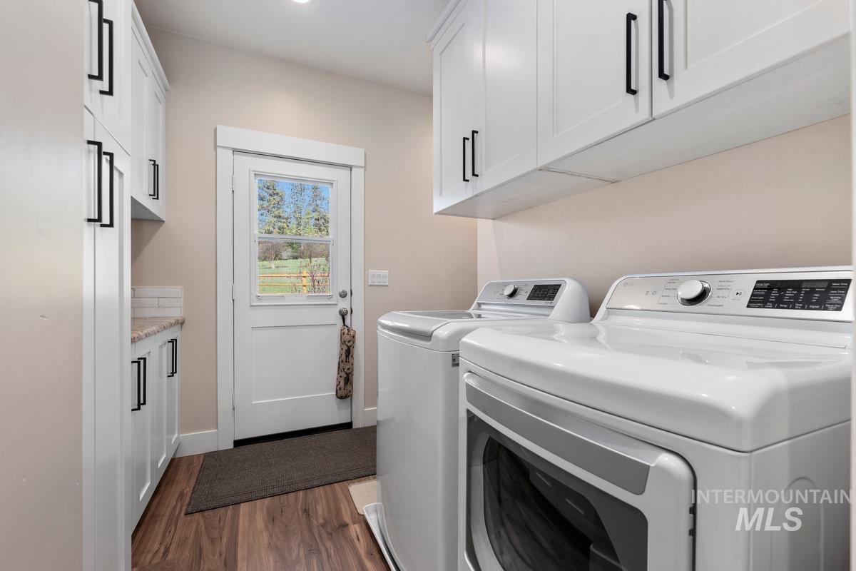 21 Open Road Garden Valley, ID 83622 - Photo 16 of 49 Laundry area with dark wood-style floors, cabinet space, and washing machine and clothes dryer