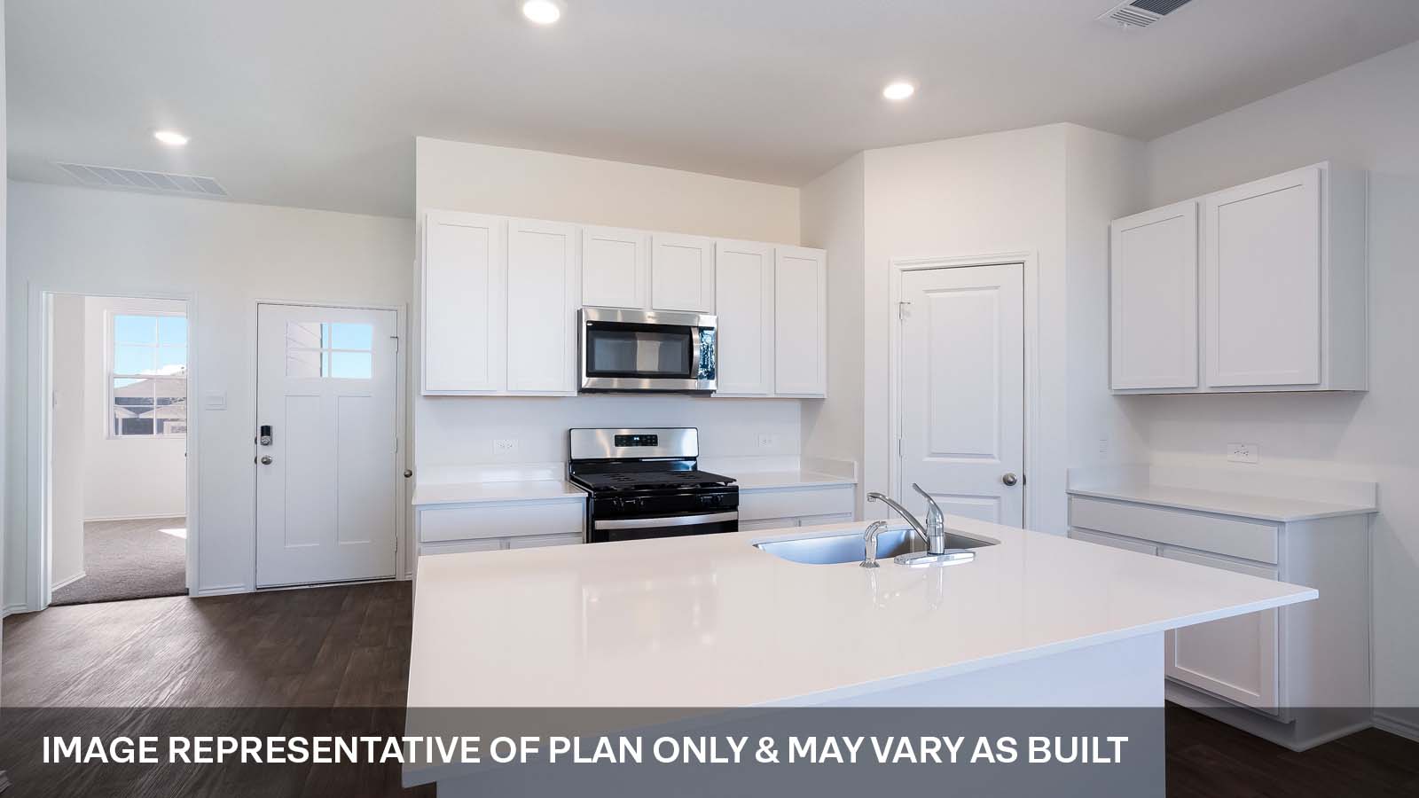 1165 Celosia Loop Kyle, TX 78640 - Photo 4 of 18 a kitchen with stainless steel appliances a sink a stove a microwave a refrigerator a white counter and cabinets