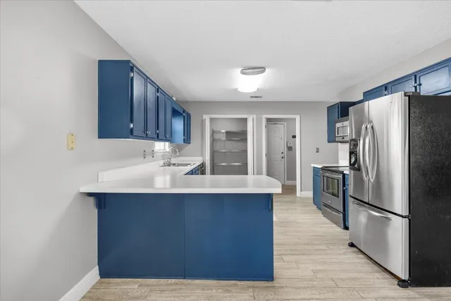 a kitchen with stainless steel appliances a sink and a refrigerator