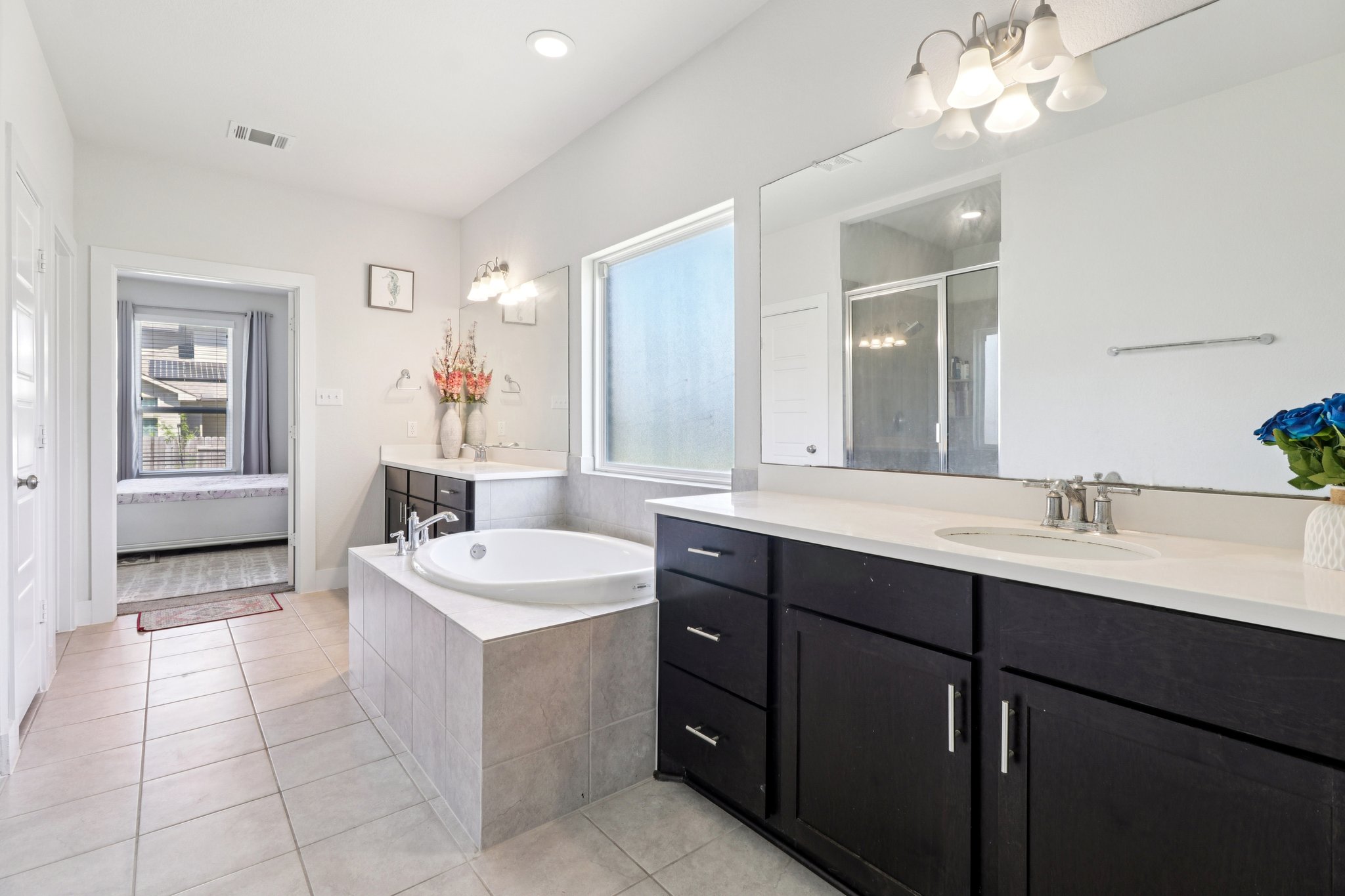 3816 Bow Perch Street Pflugerville, TX 78660 - Photo 8 of 23 a spacious bathroom with a double vanity sink a mirror and a bathtub