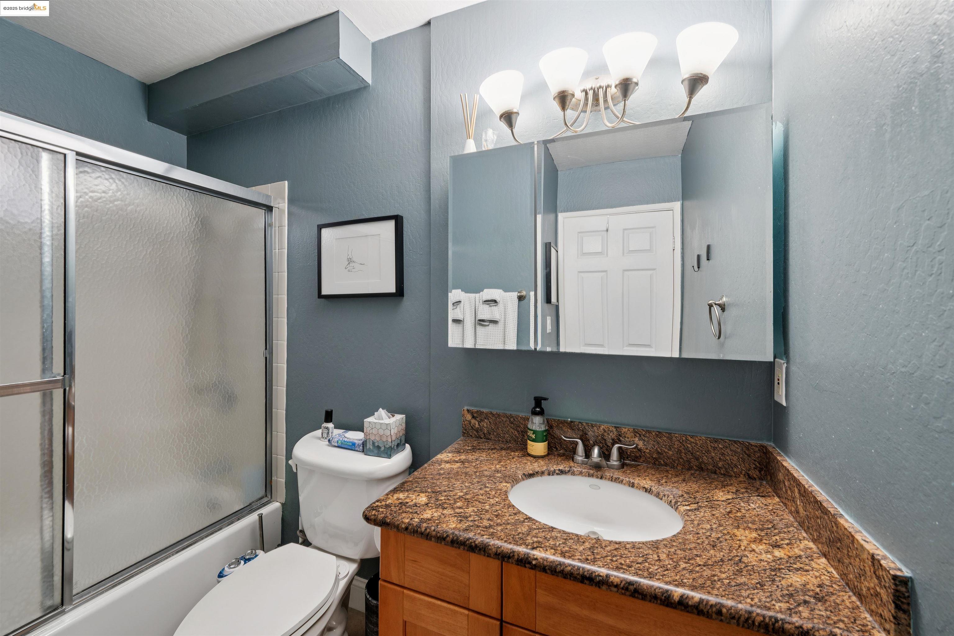 2980 Park Boulevard, Unit 1 Oakland, CA 94610 - Photo 9 of 10 a bathroom with a granite countertop sink toilet and shower