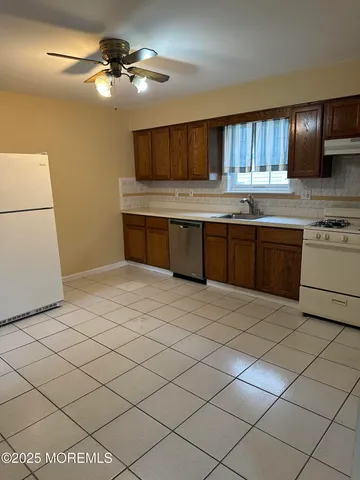 a kitchen with stainless steel appliances kitchen island granite countertop a sink a stove and cabinets