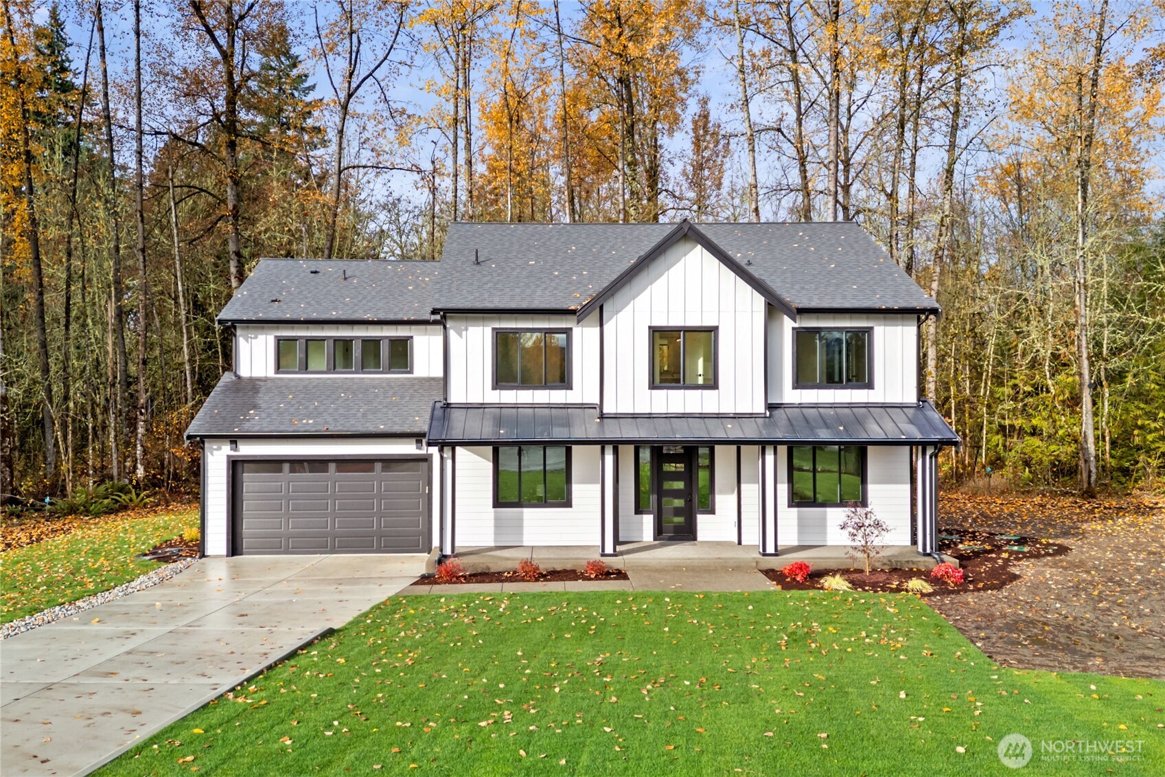 a front view of a house with a yard and trees