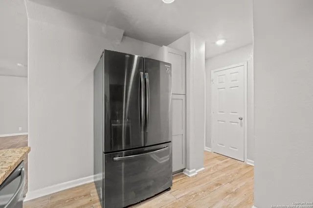 a view of a refrigerator in kitchen and wooden floor