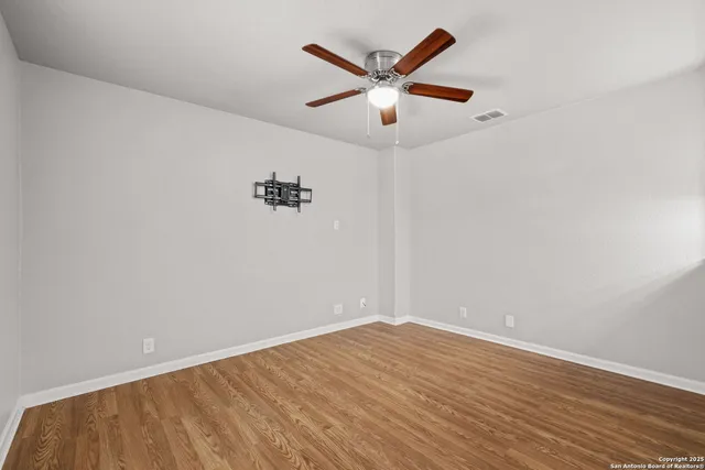 an empty room with a window and ceiling fan