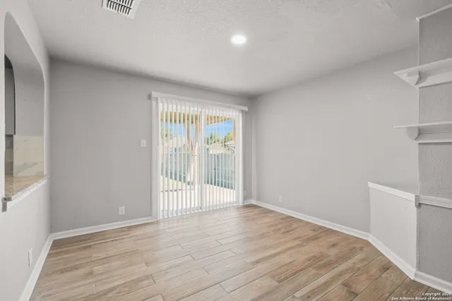 a view of an empty room with wooden floor