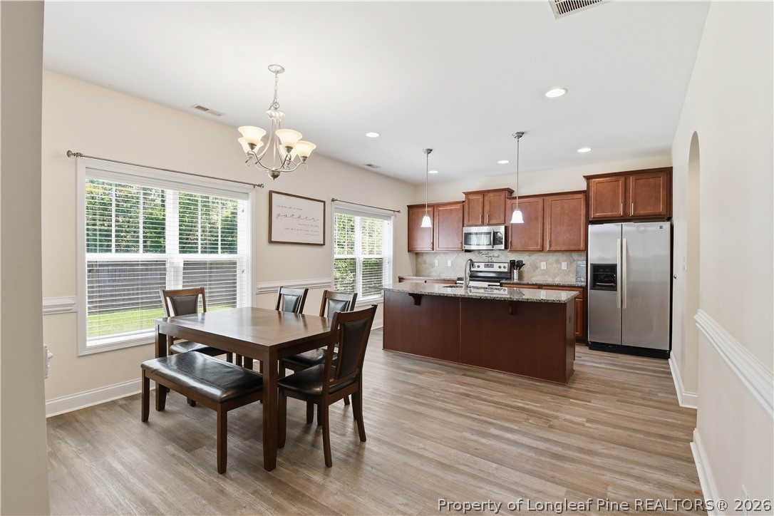 140 Birch Avenue Spring Lake, NC 28390 - Photo 20 of 49 a kitchen with a dining table chairs refrigerator and cabinets