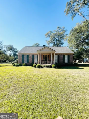 a front view of house with a garden