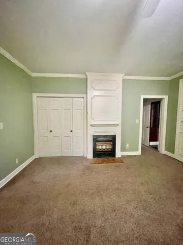 a view of an empty room with a fireplace and a window