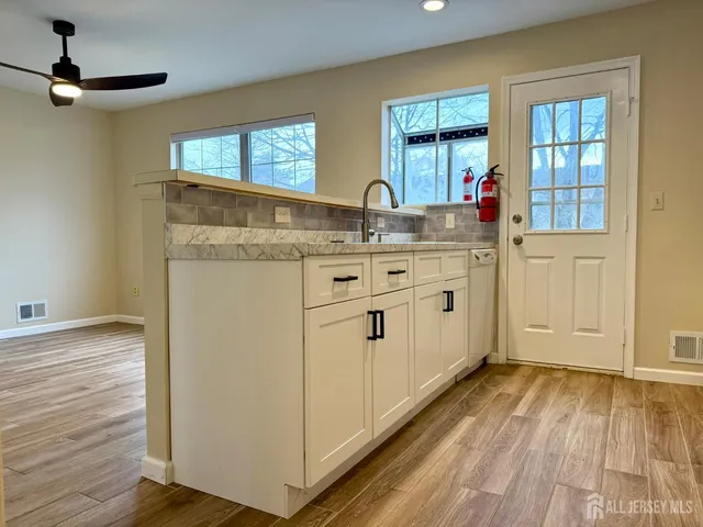 a kitchen with a sink window and cabinets