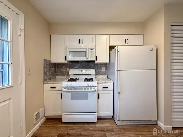 a white refrigerator freezer and a stove sitting inside of a kitchen