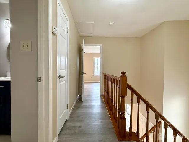 a view of a hallway with wooden floor and staircase