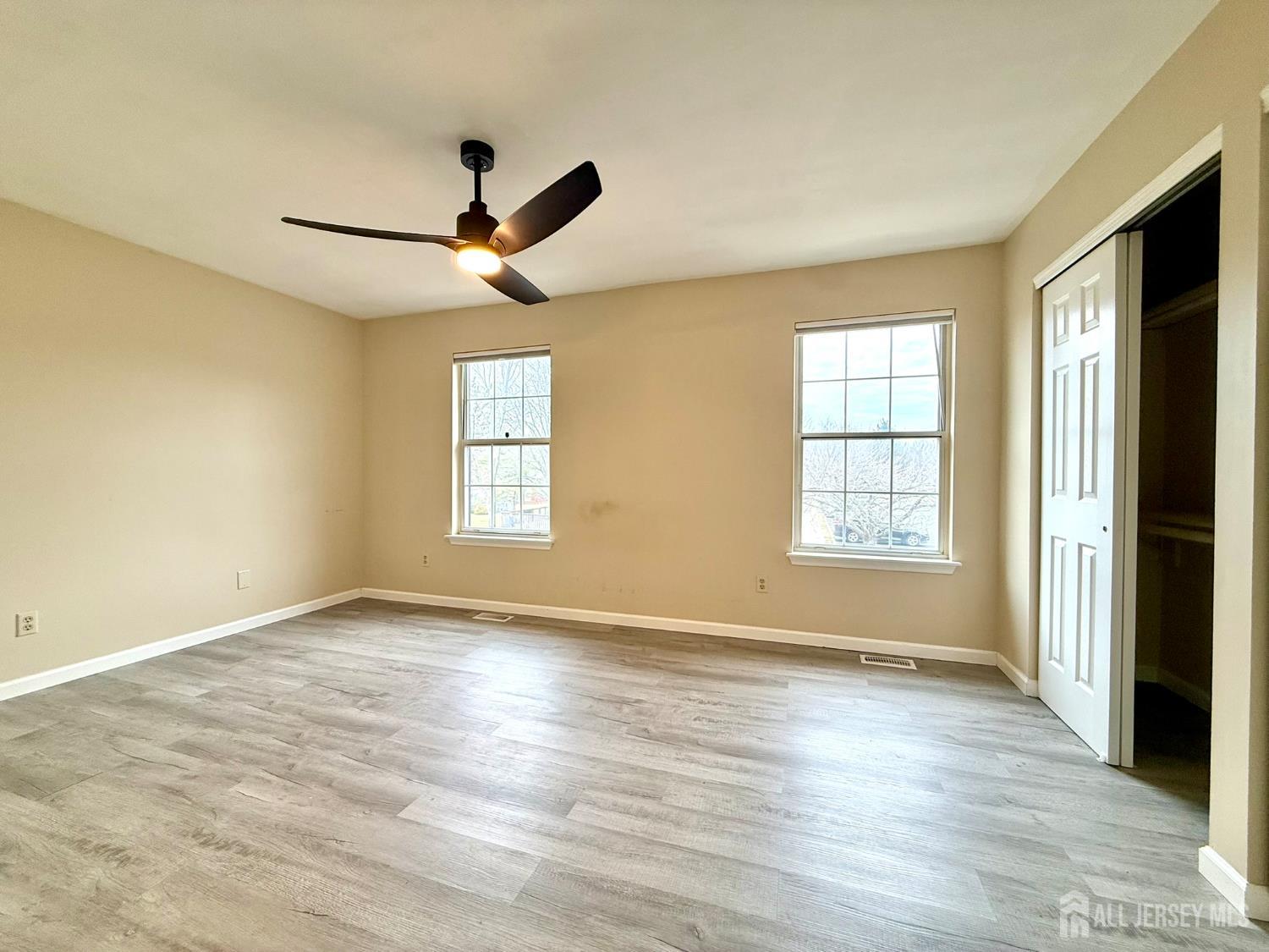 384 Inwood Court Somerset, NJ 08873 - Photo 20 of 29 an empty room with wooden floor ceiling fan and windows