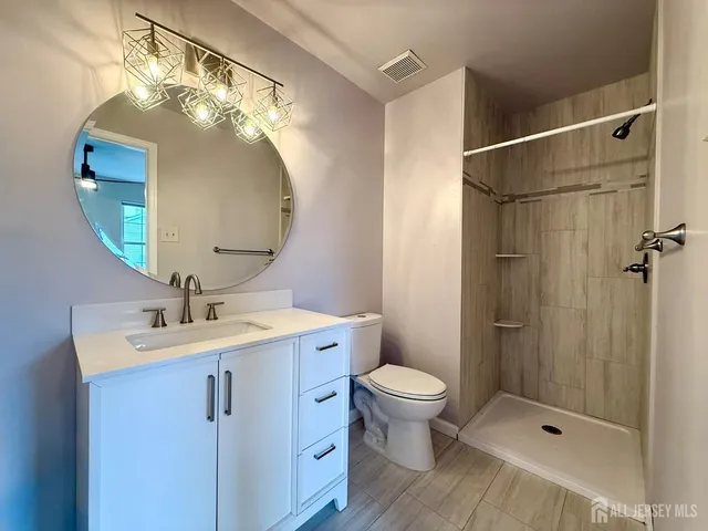a bathroom with a sink a toilet and shower