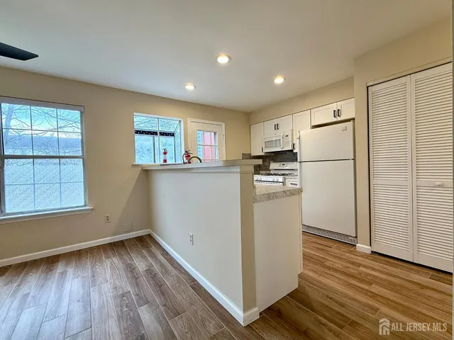 a view of a kitchen with wooden floor and electronic appliances