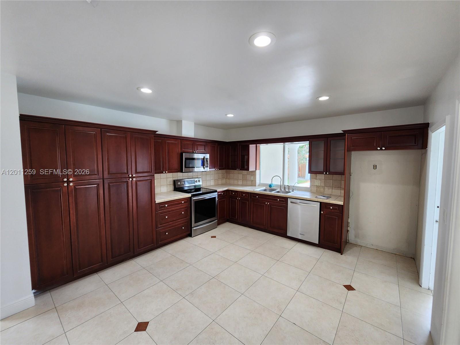 4233 Jackson Street Hollywood, FL 33021 - Photo 11 of 28 a large kitchen with a large counter top space and stainless steel appliances