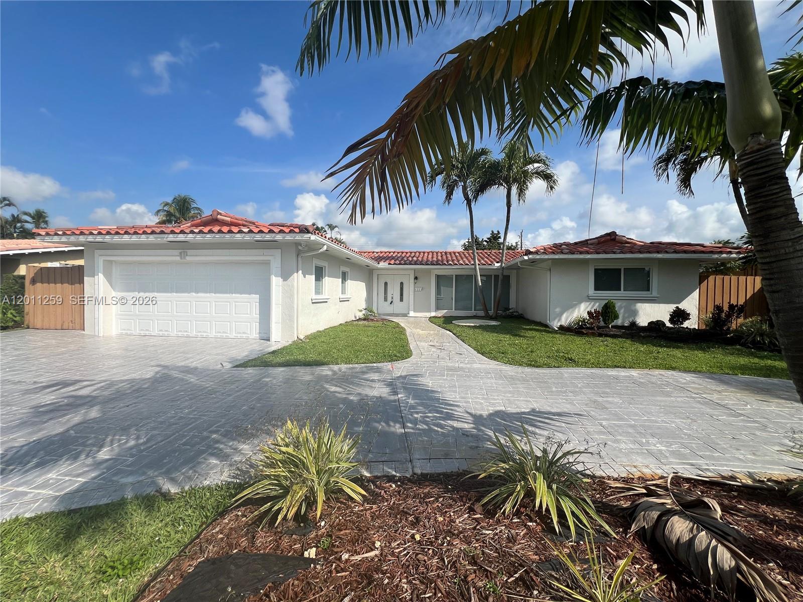 4233 Jackson Street Hollywood, FL 33021 - Photo 4 of 28 a view of a house with a yard and palm trees
