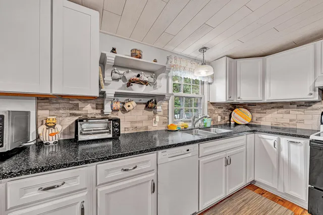 a kitchen with stainless steel appliances granite countertop a sink a stove and cabinets