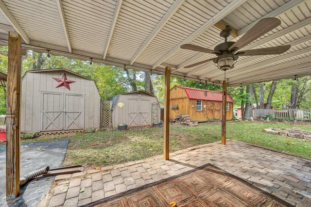 a big house with large trees and wooden fence