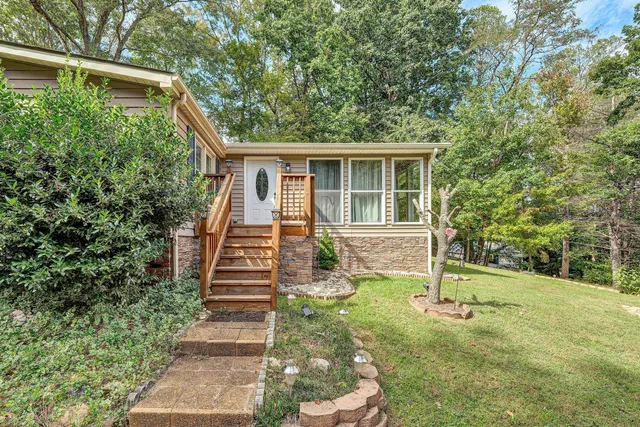 a view of a house with backyard and wooden fence