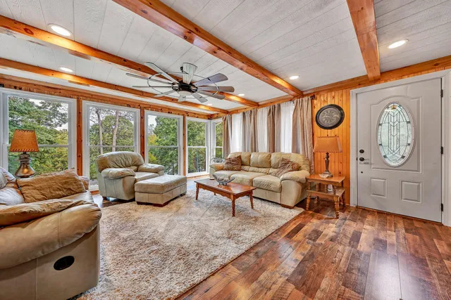 a living room with furniture a large window and a clock