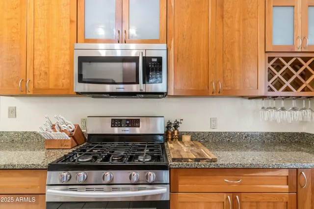 a kitchen with granite countertop stainless steel appliances a stove a microwave and cabinets
