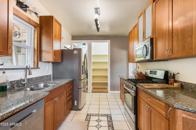a kitchen with stainless steel appliances granite countertop a sink stove and refrigerator